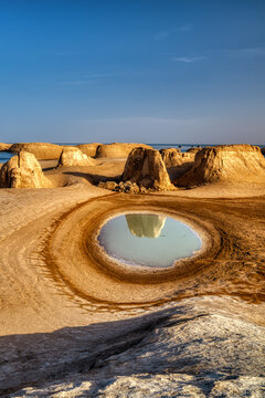 Yardang landforms and reflection in lake in sunset. Location: Wusute (Aquatic) Yadan Geological Park, Qinghai province, China. 