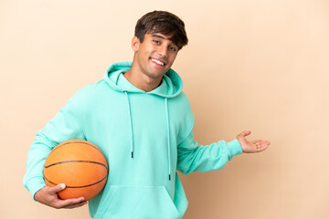 Handsome young basketball player man isolated on ocher background extending hands to the side for...