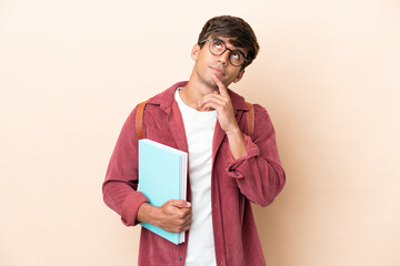 Young student caucasian man isolated on ocher background having doubts while looking up