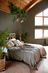 Luxurious master bedroom in modern style with big window in the log house. Wooden bed and attic ceiling.