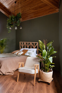 Luxurious master bedroom in modern style with big window in the log house. Wooden bed and attic ceiling.