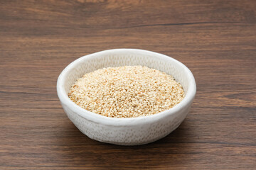 Organic White Sesame Seeds (Sesamum indicum) or Wijen, served in small bowl on wooden background
