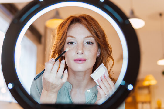 Vlogger recording make-up tutorial at home