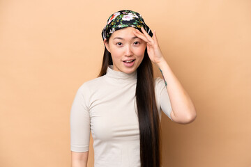 Young Chinese woman isolated on beige background has realized something and intending the solution
