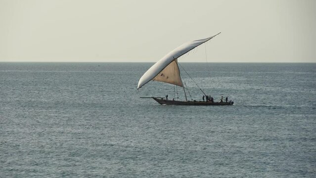 traditional commercial sailing dhow on the ocean water entering leaving harbour port heading for destinations