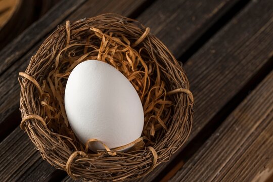 top view close-up of a single Egg in a wooden nest on the table in 4k image