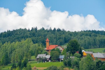 Wooden church in sunny summer on top of the mountain in background sky and clouds.