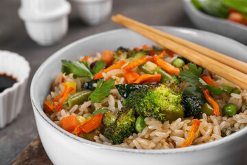 Tasty fried rice with vegetables in bowl, closeup