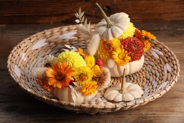 Composition with small pumpkins, beautiful flowers and spikelets on wooden table, closeup