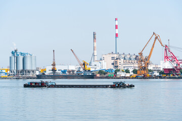 View of industrial plant and smoke stacks ,Container ship on river harbor, Shanghai, China