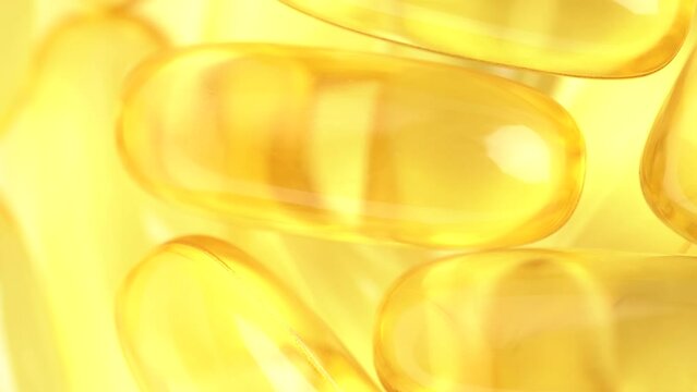 Food supplement oil filled. Capsules with omega 3 or vitamin A, E, fish oil. Macro shot, slow motion, top view. Pills background, capsules texture
