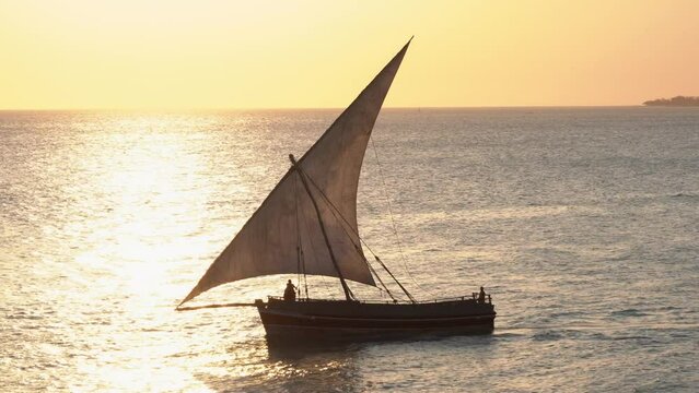 traditional commercial sailing dhow on the ocean water entering leaving harbour port heading for destinations