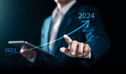 2023  to 2024 business target concept. Businessman analyzes the graph of increasing profit growth in 2024. Marketing and financial plan, Start business goal for new year. - obrazy, fototapety, plakaty