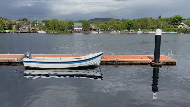 Wood slat motorboat tied to floating dock on Shannon River in Ireland