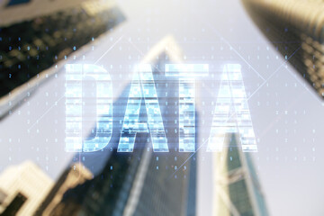 Data word hologram on blurry cityscape background, big data and blockchain concept. Multiexposure