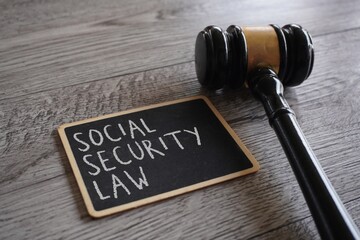 Closeup image judge gavel and chalkboard with text SOCIAL SECURITY LAW.