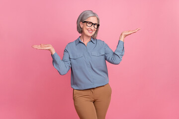 Portrait of optimistic funny person with gray short hair wear stylish shirt palms presenting offer empty space isolated on pink background