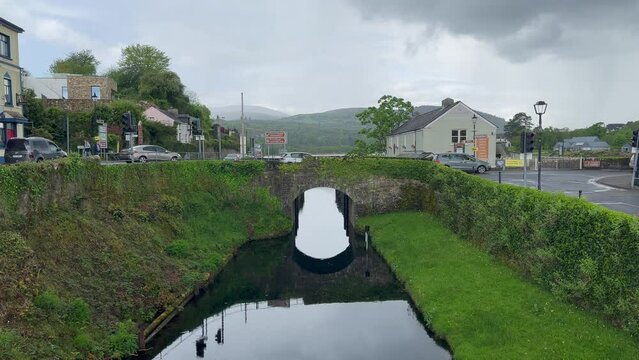 Stone arch bridge crosses river side canal in green Killaloe Ireland