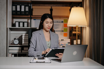 Young beautiful woman work late from home in room at late night overtime.Businesswoman bending over...