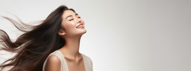 Elegant Smiling Asian Model Showcasing Silky Smooth Black Hair for Haircare with Copy-Space - obrazy, fototapety, plakaty
