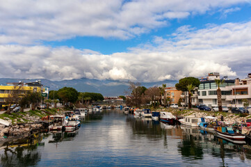 Fototapeta na wymiar Fishing boats on the river, cloudy sky, reflection.