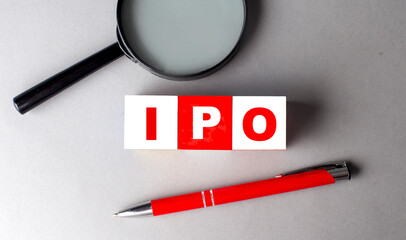 IPO word on wooden cubes with pen and magnifier