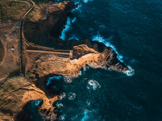 Aerial view of the coasts and cliffs of the island of Sao Miguel over the lighthouse of Farolim dos Fenais da Ajuda, Azores Islands, Portugal, Atlantic