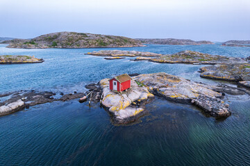 Scenic lonely wooden red house on a rocky island at dusk, Bohuslan, Sweden, Scandinavia