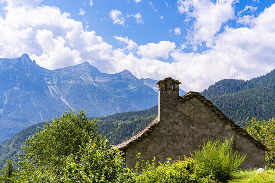 A traditional rural architecture style house built of rocks from the mountain in a beautiful alpine valley in summer, Piemonte (Piedmont), Northern Italy