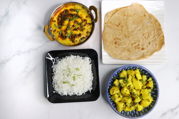 Indian vegetarian Thali or platter includes Aloo ki sabji, dal rice, Roti bhaji, Matar Paneer, Sheera or suji ka halwa, chapati. Indian food is served in a Silverplate or thali. Copy Space. Veg Thali - obrazy, fototapety, plakaty