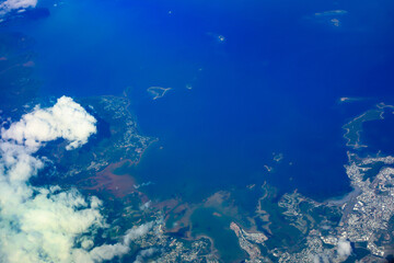 Sky high above the Clouds - Ariel View of Land and Sea from the Plane 