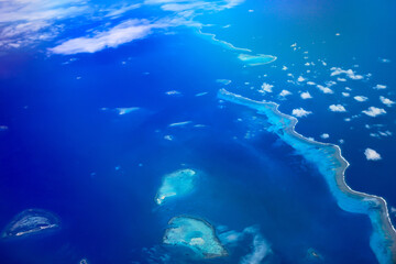 Fototapeta na wymiar Sky high above the Clouds - Ariel View of the Beautiful Islands and Ocean from the Plane 