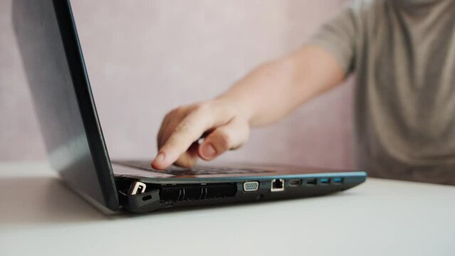 A man opens a broken laptop, the laptop hinge is loose and broken, close-up