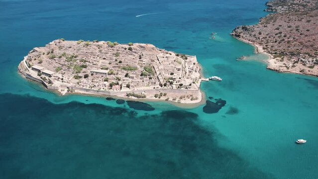 Spinalonga - Greek arid rocky islet. Famous small island near Elounda in East Crete seen from aerial perspective. Summer holidays concept. High quality 4k footage