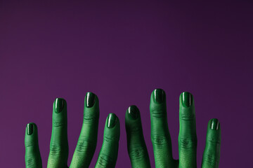 Green, painted hands on a purple background.