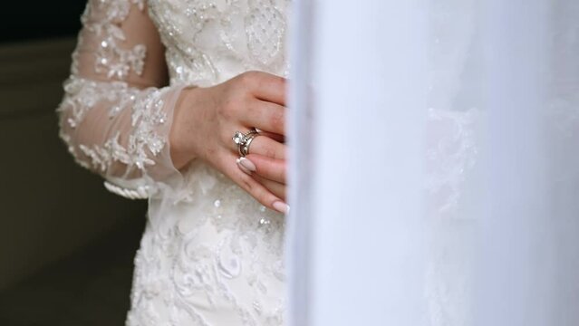 the bride twists the wedding ring on her finger while at home. medium plan. scratched hands from a cat. bride waiting to meet