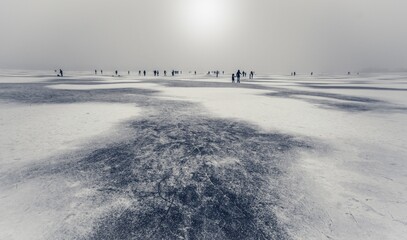 Silhouettes of people on a frozen lake.