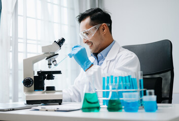 Modern medical research laboratory. male scientist working with micro pipettes analyzing...