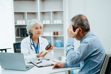 Asian Senior Doctor and patient discussing something while sitting at the table . Medicine and health care concept.