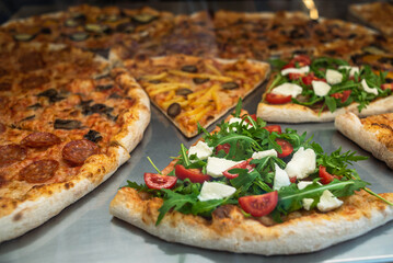 Close-up of a slice of pizza in a cafe. Sale of ready-made pizza in a pizzeria. Italian pizza