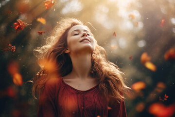  Beautiful smiling carefree woman with opened arms in a meadow in autumn