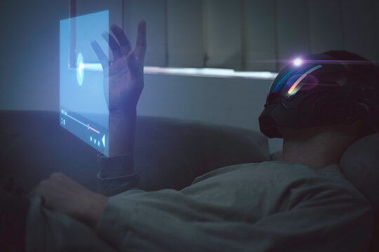 man Wearing AR Headset Design touching futuristic social media online content, freelance worker, working online, content creator, woman using laptop, man reading blog online on computer. - Powered by Adobe