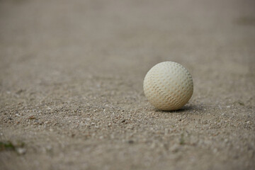 昼のグランドの地面にある野球のボールの様子