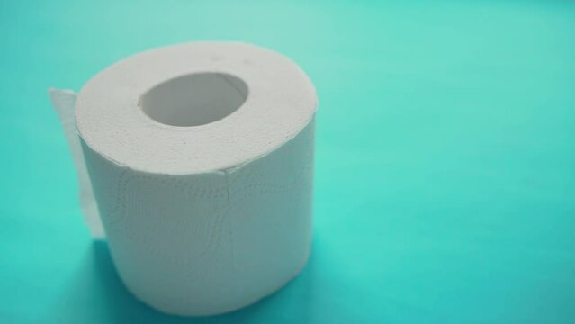 A roll of high-quality soft toilet paper with perforations on a blue background. The concept of multi-layer cellulose toilet paper, care and hygiene. Copy space for text