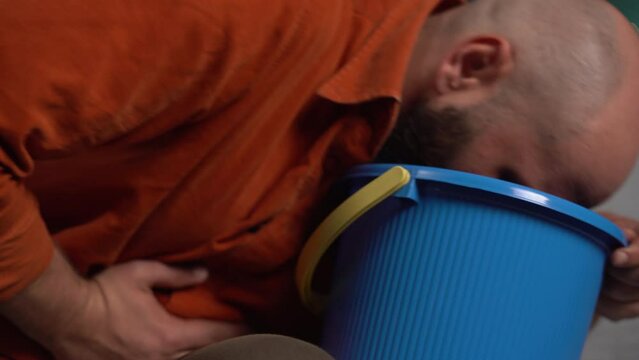 Bearded man suffering from nausea, vomiting and indigestion at home