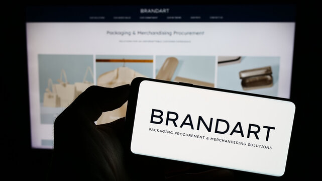 Stuttgart, Germany - 09-20-2023: Person holding cellphone with logo of Italian packaging company Brandart  SpA on screen in front of business webpage. Focus on phone display.
