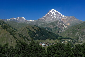 Fototapeta premium カズベク山とゲルゲティ三位一体教会とゲルゲティ村 
