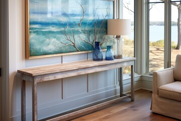 Fototapeta na wymiar window view of a sea landscape painting hung above a weathered oak console table