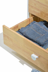 Perfect and neatly setting of clothes. Jeans drawer organize isolated on white background. Perfectionist.