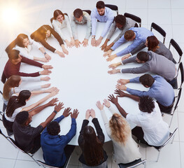 Businessmen and women in meeting at large round table, elevated view